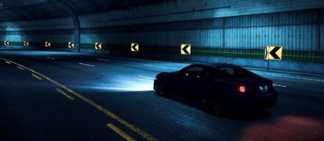 Fahrzeug auf einer Straße in einem Tunnel. Es ist dunkel und das Licht es Fahrzeugs spiegelt sich auf der Straße